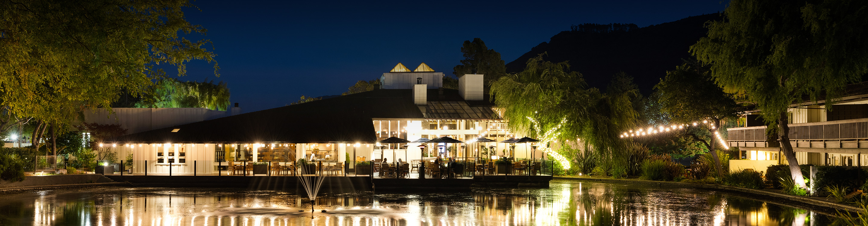 a building with trees around it and a body of water