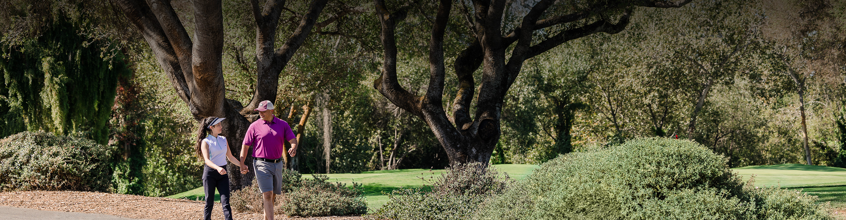 a man and woman walking through a park