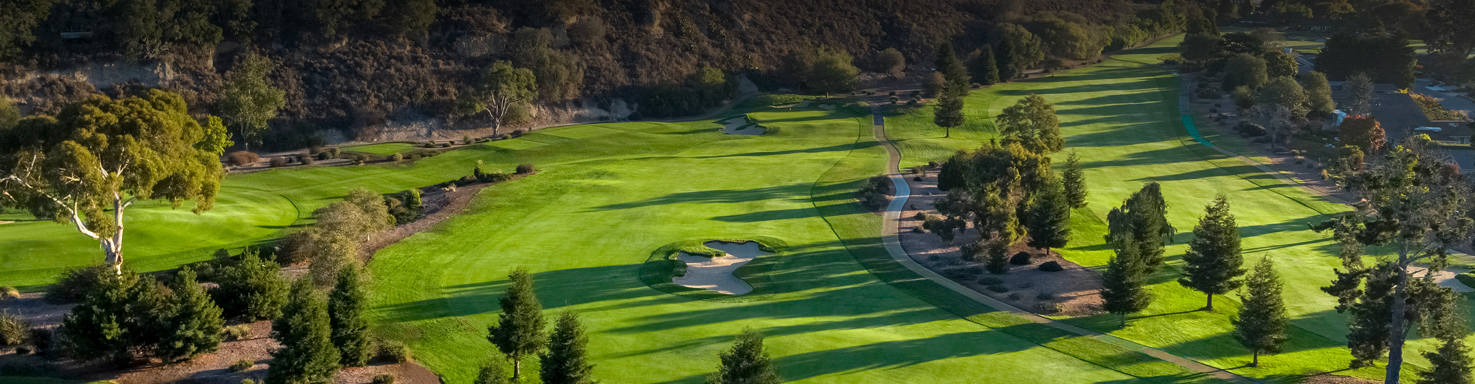 a golf course with trees and grass