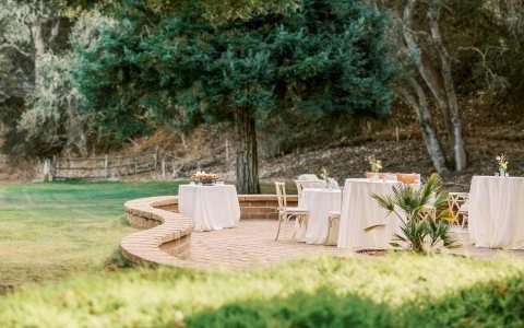 tables and chairs set up outside with white table cloths