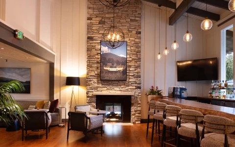 a room with a fireplace, seating and bar