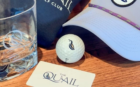 a golf ball, hat and a card on a table