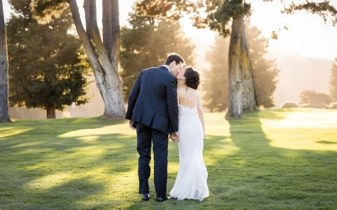 a man and woman kissing on grass