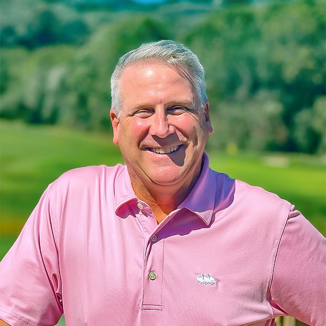 a man with grey hair and a pink shirt